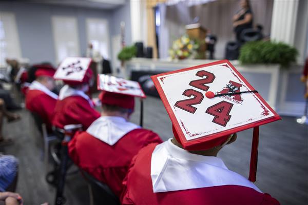 The tops of the caps of the HKS Graduates decorated. The cap in the foreground reads \